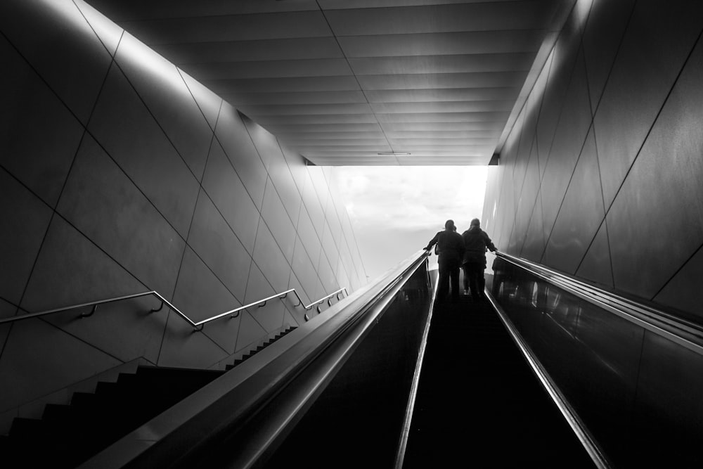 a couple of people walking down a tunnel