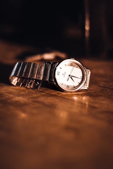 A close-up of a stylish watch on a wooden surface.