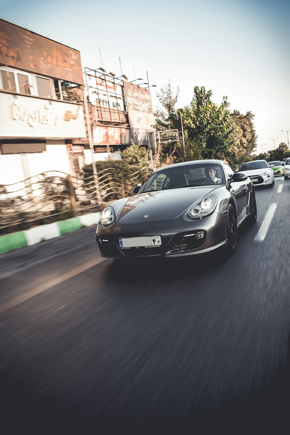 a black sports car driving down a street