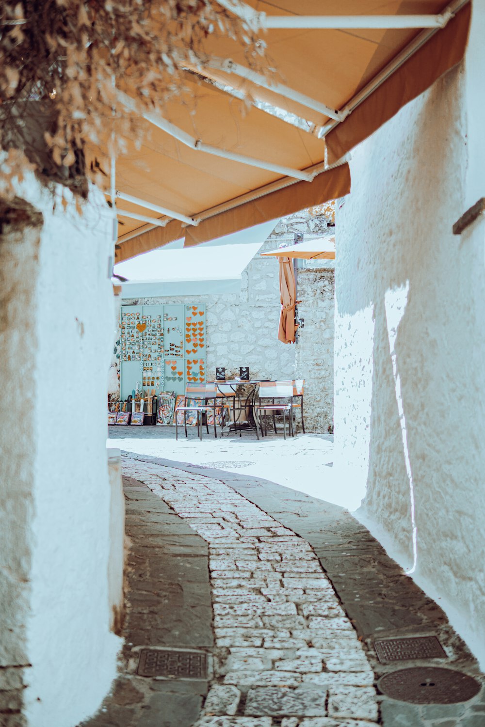 a stone walkway with tables and chairs