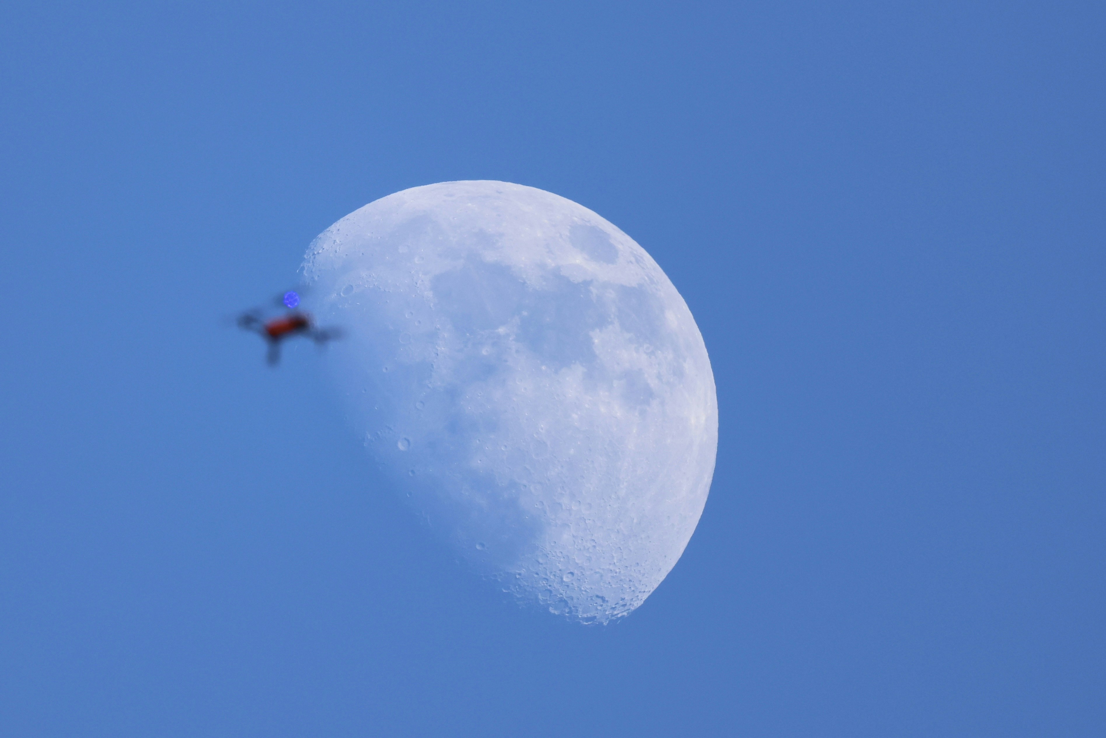 A helicopter flying over a large moon photo – Free Astronomy Image on ...