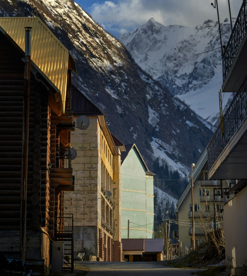 a row of buildings in front of a mountain