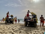 Lifeguards practicing rescue techniques on a sunny beach.