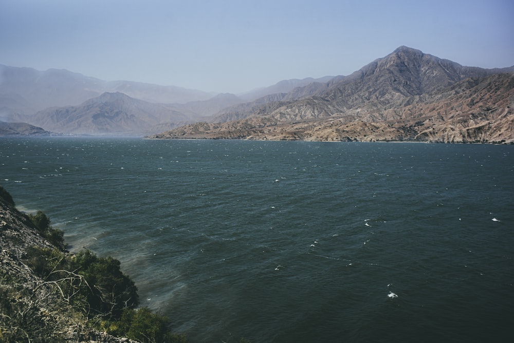 a body of water with mountains in the background