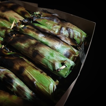 Close-up of a vibrant cochinita pibil bomb with rich orange hues and textured banana leaf wrapping.