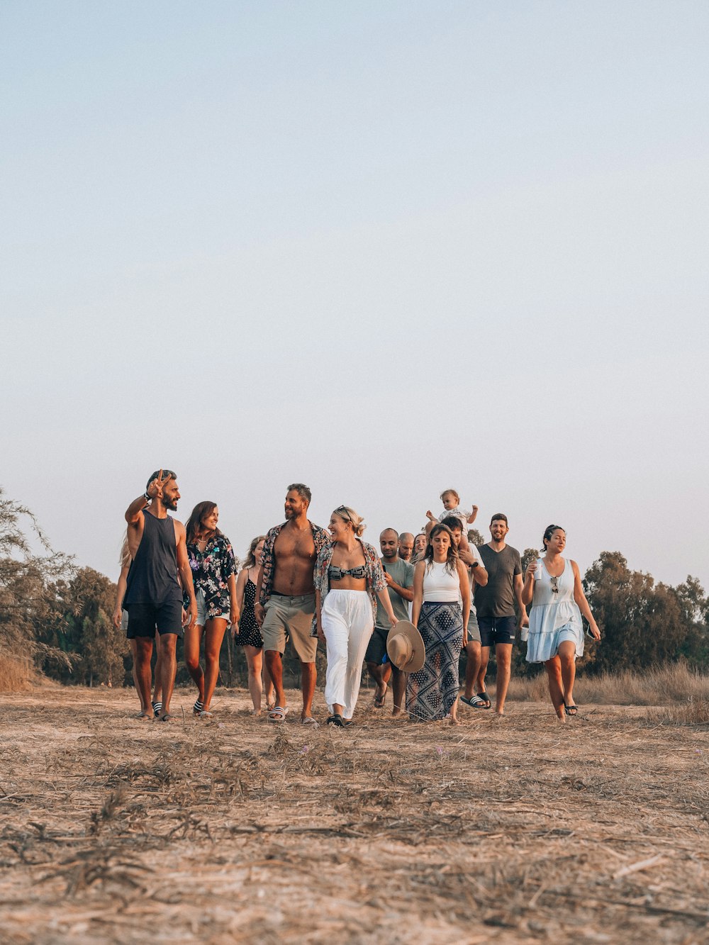 a group of people standing on a dirt road