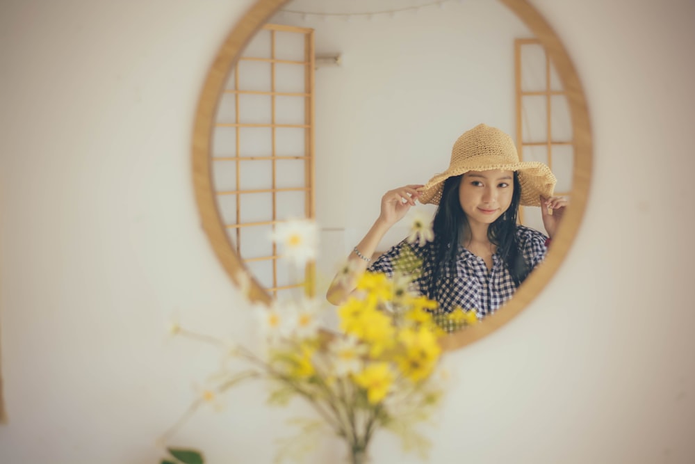 a woman in a hat holding flowers