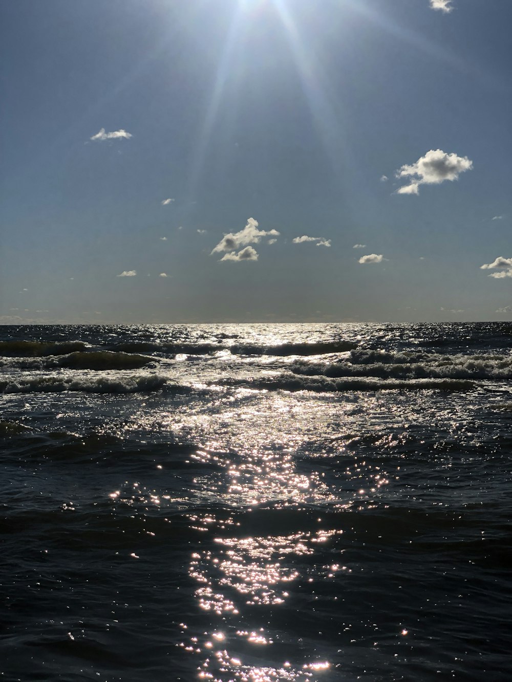 a body of water with rocks and a blue sky