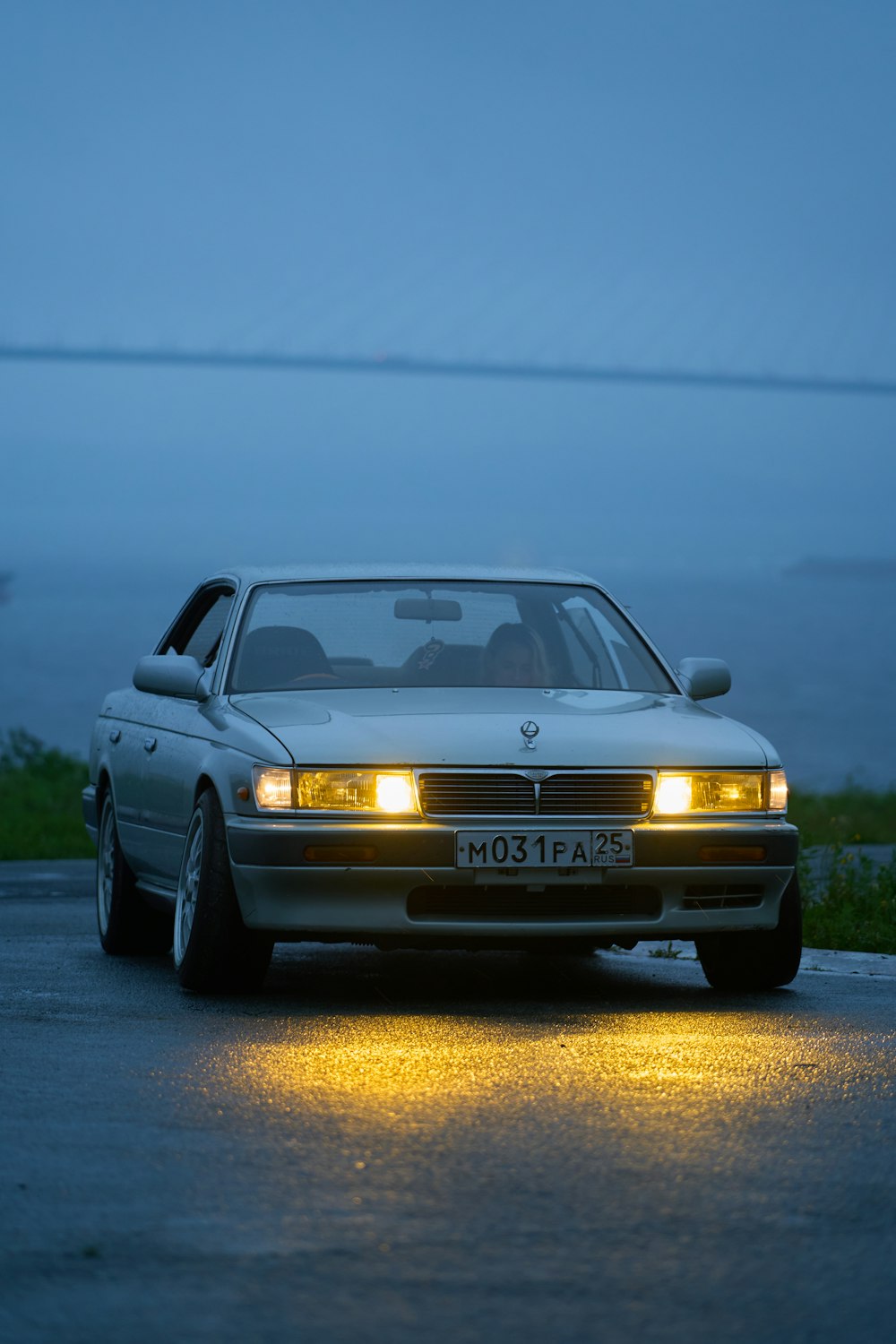 a car on a road with water in the background