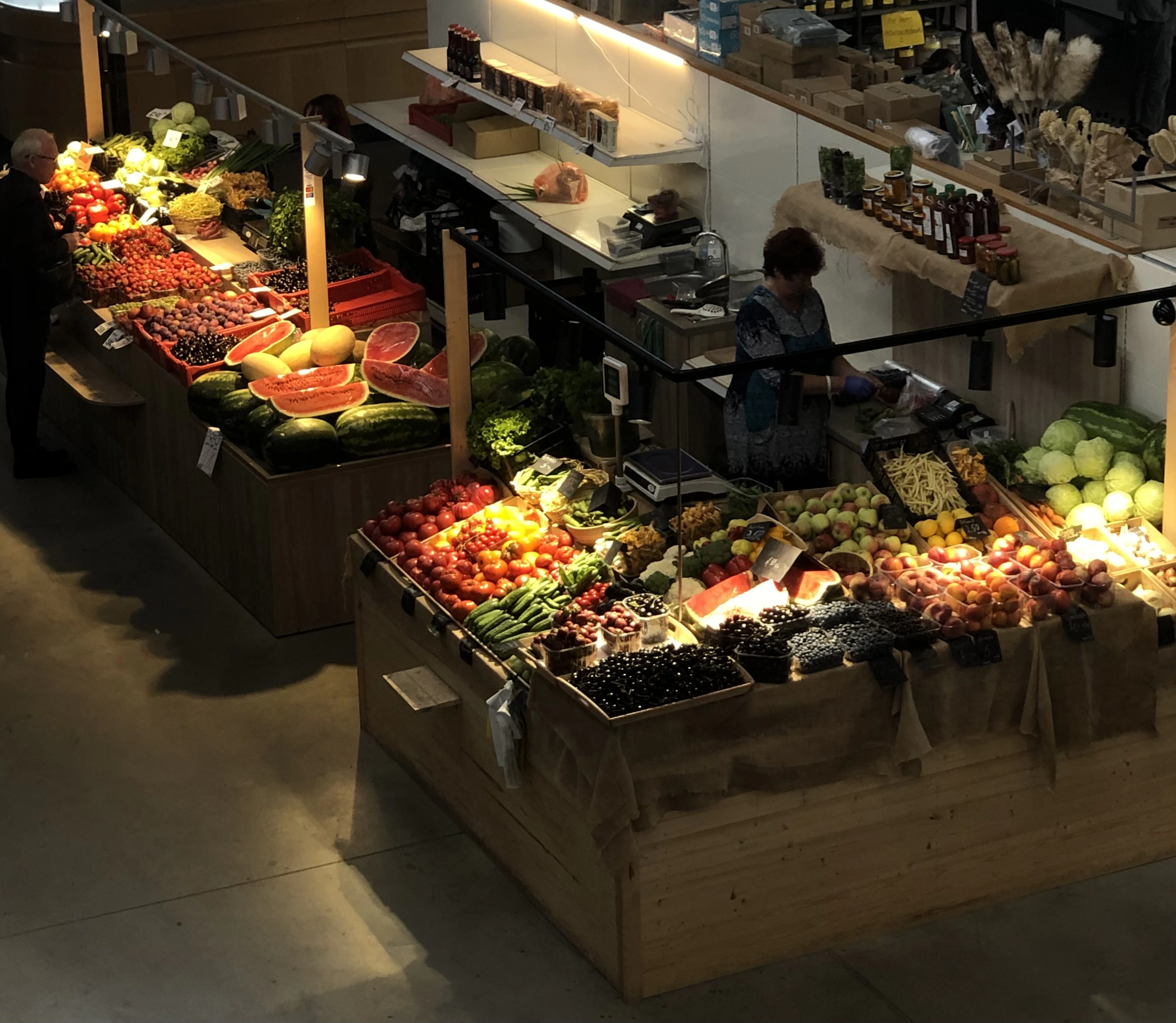 Fruit and vegetable stalls piled with produce inside Agenskalns Market hall in Riga, Latvia