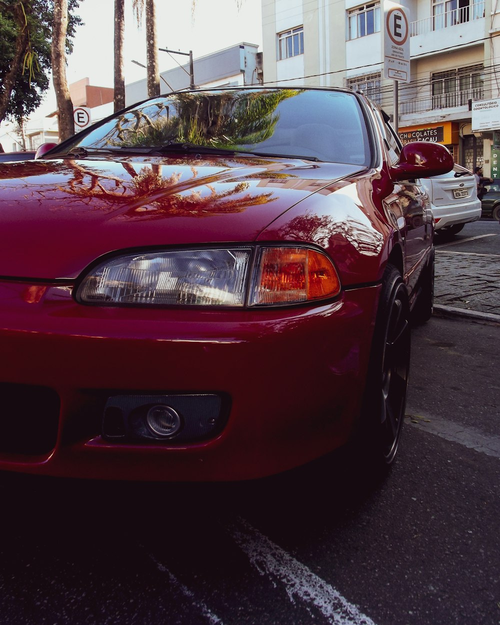 a red car parked on the side of a road