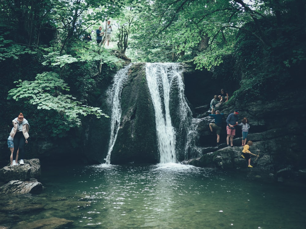 a man standing next to a waterfall