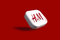 A red and white 3D button with the letters 'H & M' prominently displayed against a vibrant red background.