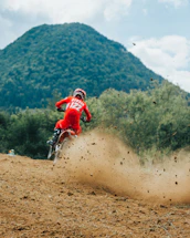 a person riding a bike on a dirt trail with trees in the background