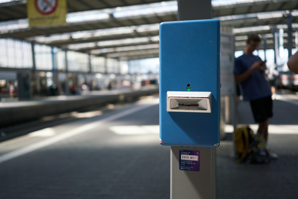 a blue post with a person standing in the background