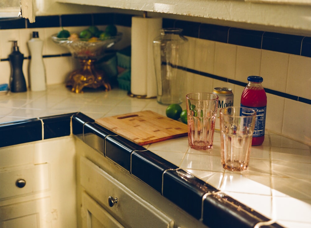 a kitchen counter with a couple of glasses and a knife on it