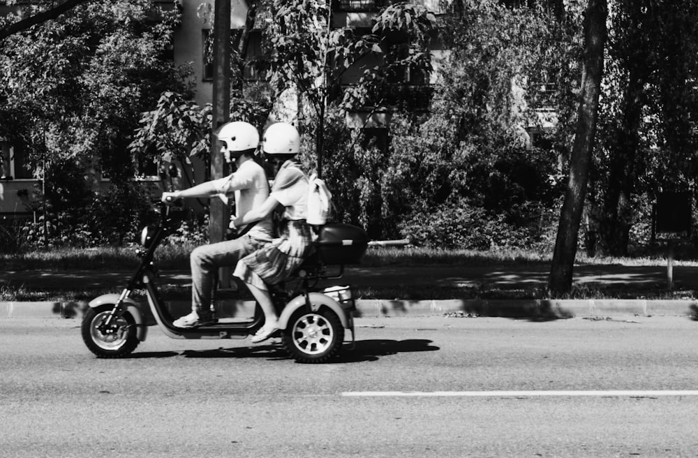 a couple of people ride on a moped