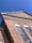 A red brick building with large windows and an intricate cornice under a clear blue sky. Security cameras are mounted at the top corner.