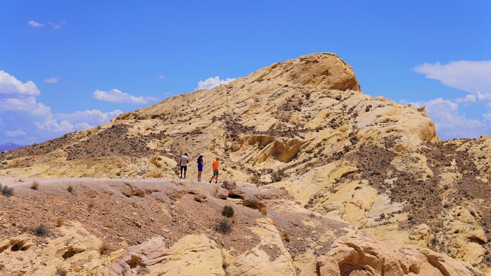 a group of people standing on a rocky hill