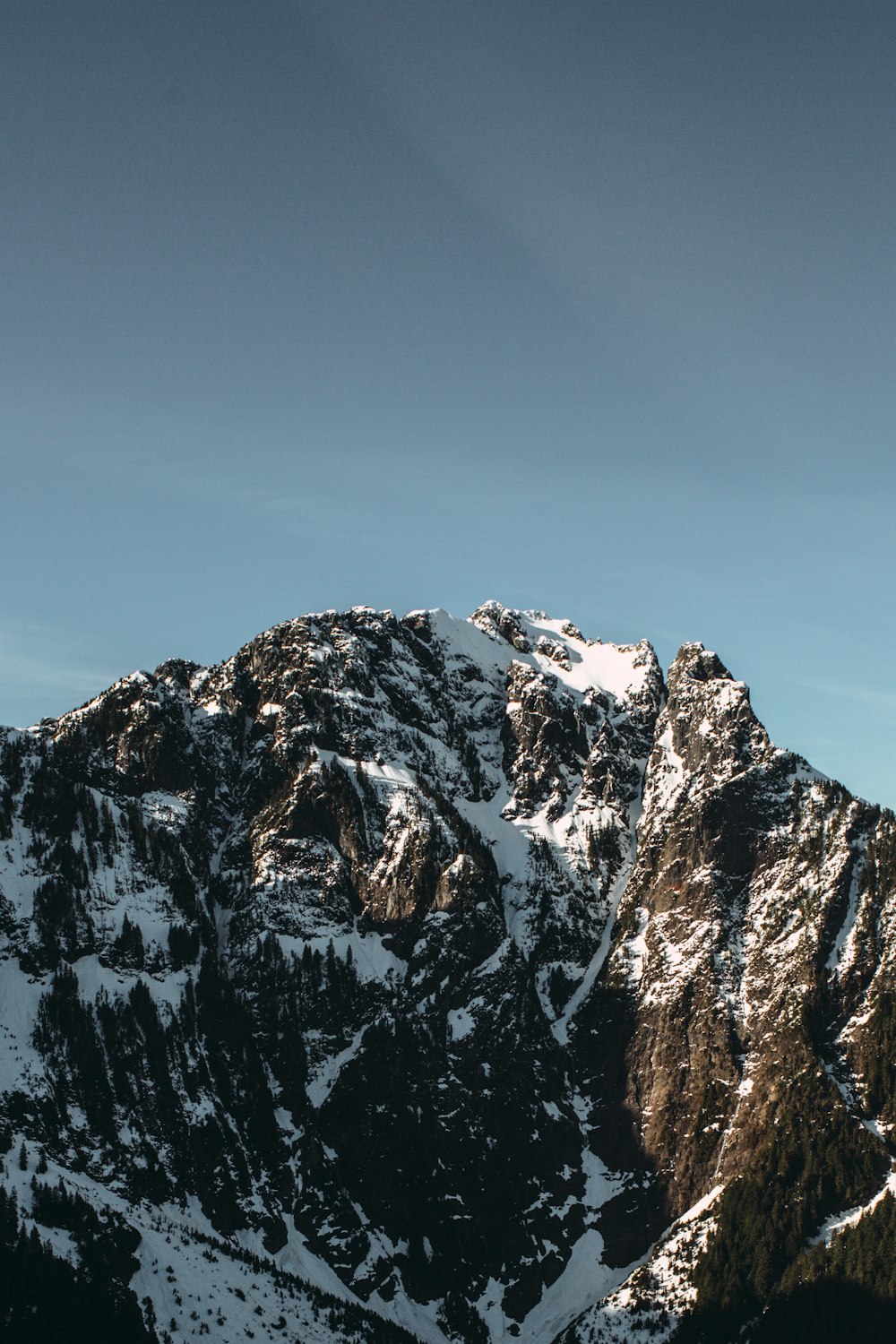 a snowy mountain with a blue sky