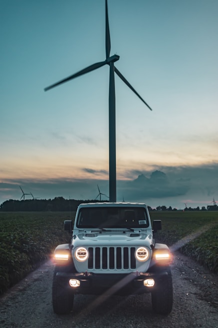 A Liberty Energy Services truck parked at a wind turbine site during sunset