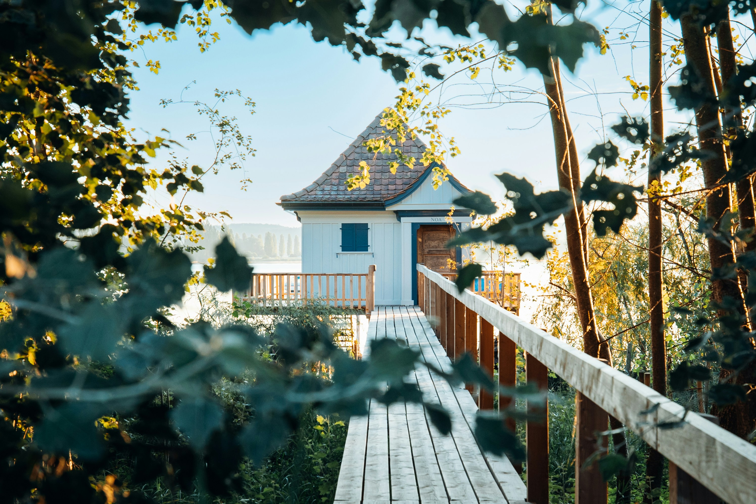 a wooden bridge leading to a house