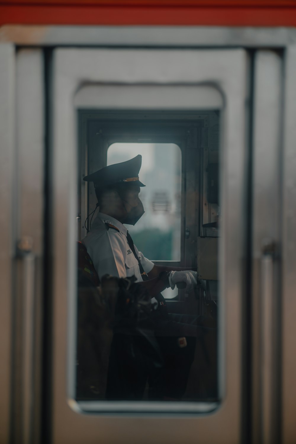 a person in a hat and coat in a window