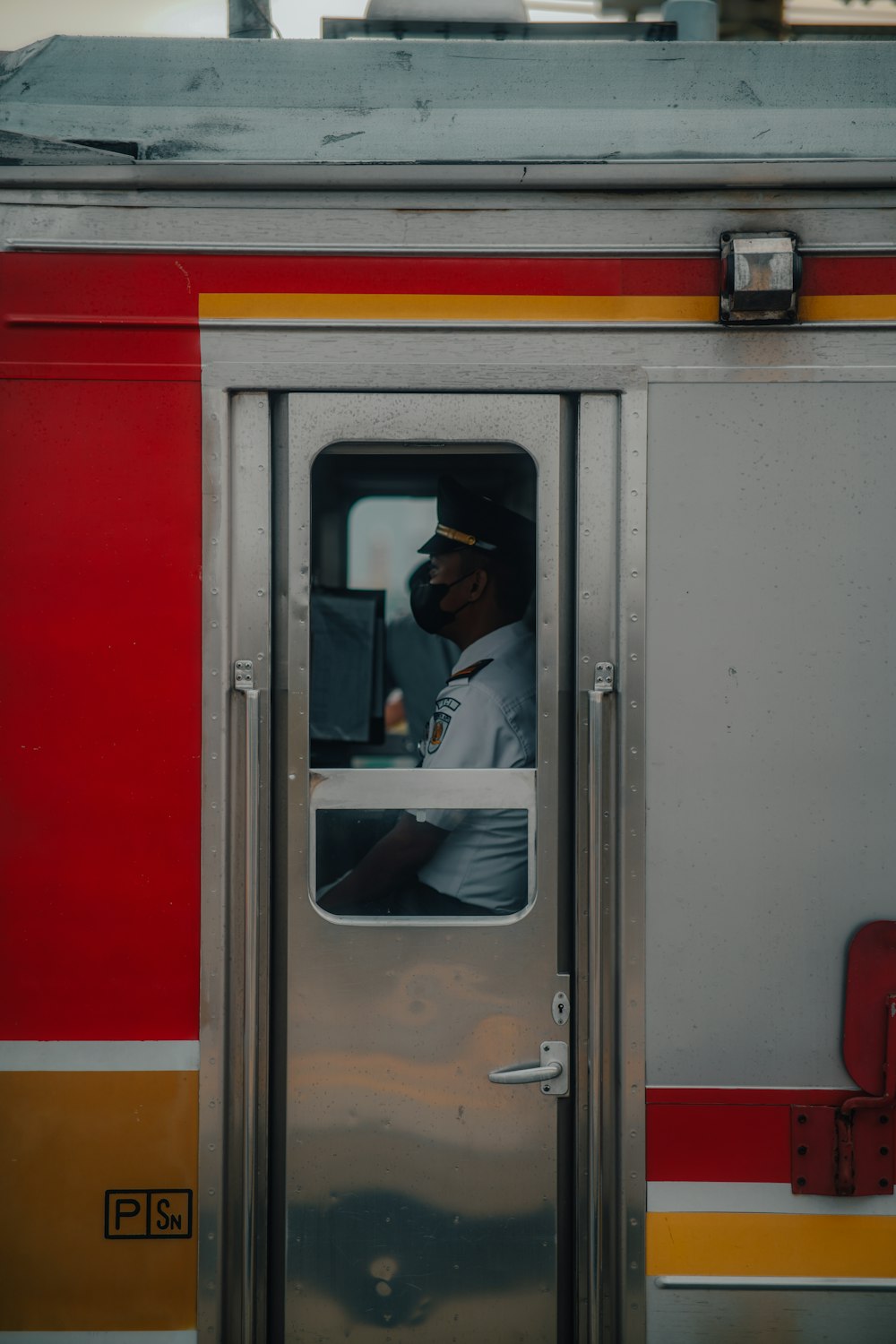 a person in a hat looks out a train window