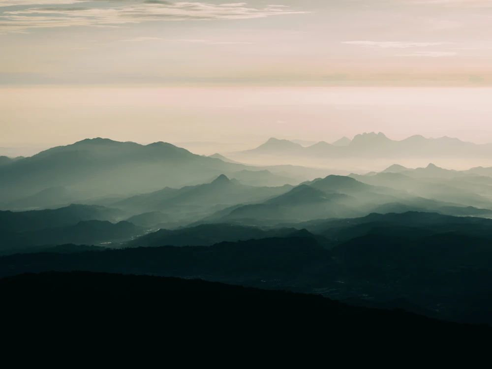 a landscape with hills and fog