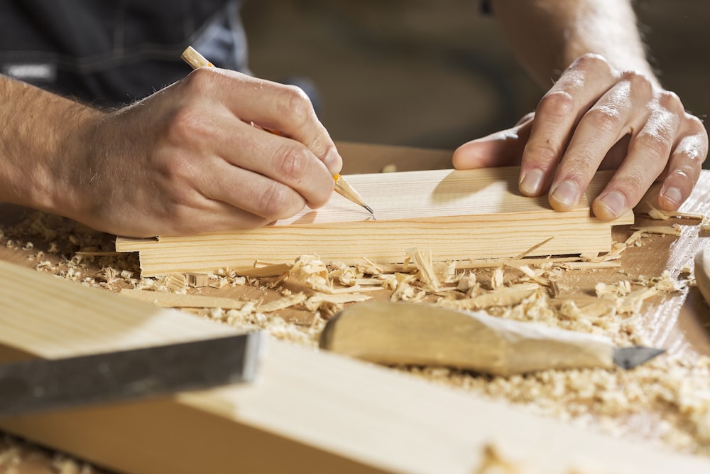 a person cutting a piece of wood