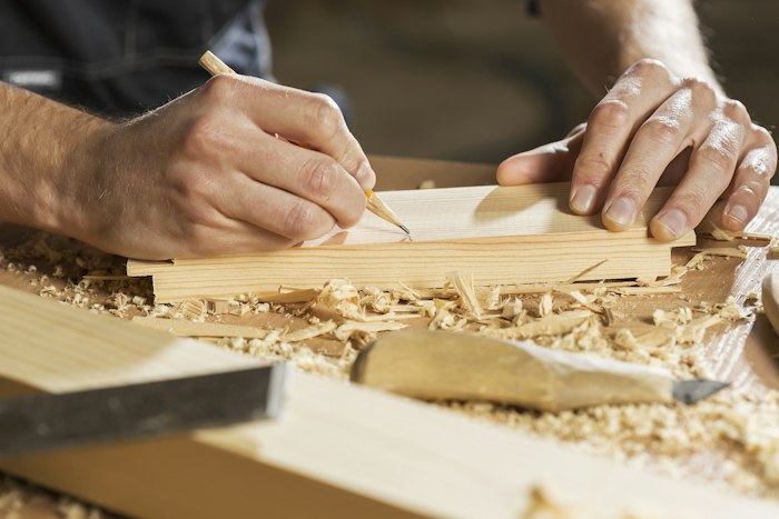 Carpenter marking and measuring wood for a custom piece