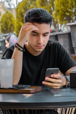 Freelancer looking at his phone working on his JobberBooks bookkeeping needs.