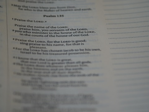 A close-up of a page from a book, specifically showing Psalm 135 with text focused on praise and worship. The text is clearly visible and legible, with a portion emphasized by slightly larger and bold font.