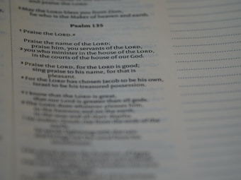 A close-up of a page from a book, specifically showing Psalm 135 with text focused on praise and worship. The text is clearly visible and legible, with a portion emphasized by slightly larger and bold font.