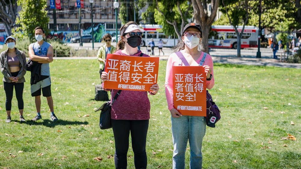 Un par de mujeres sosteniendo carteles