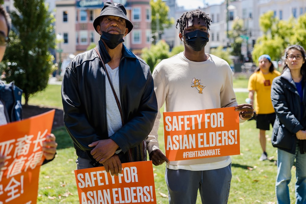 a couple of men wearing masks and holding signs