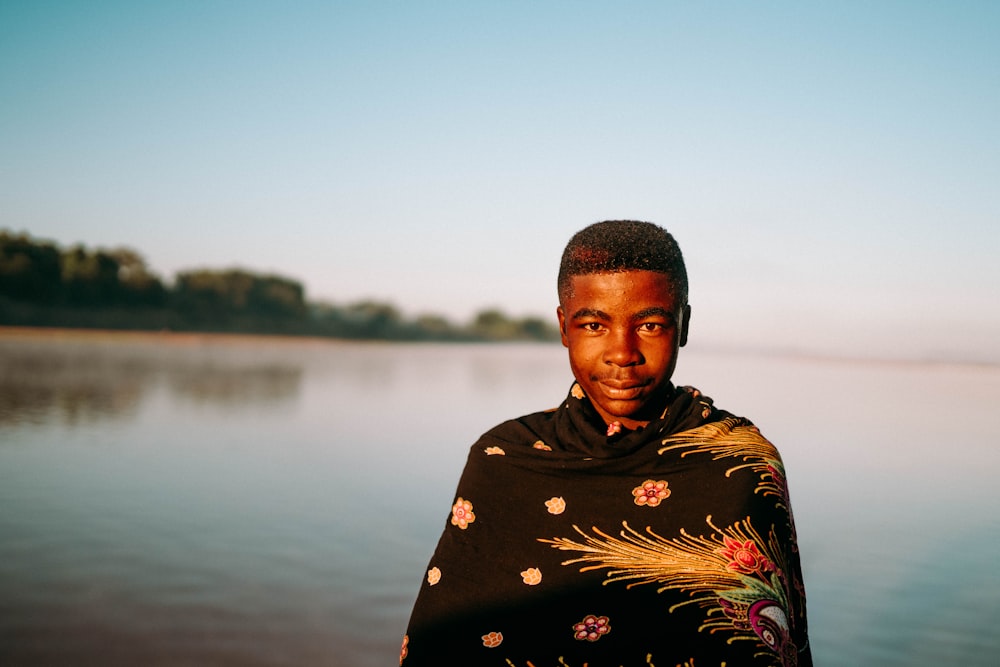 a man standing in front of a body of water