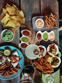 Variety of colorful Mexican tacos arranged on a rustic wooden table.