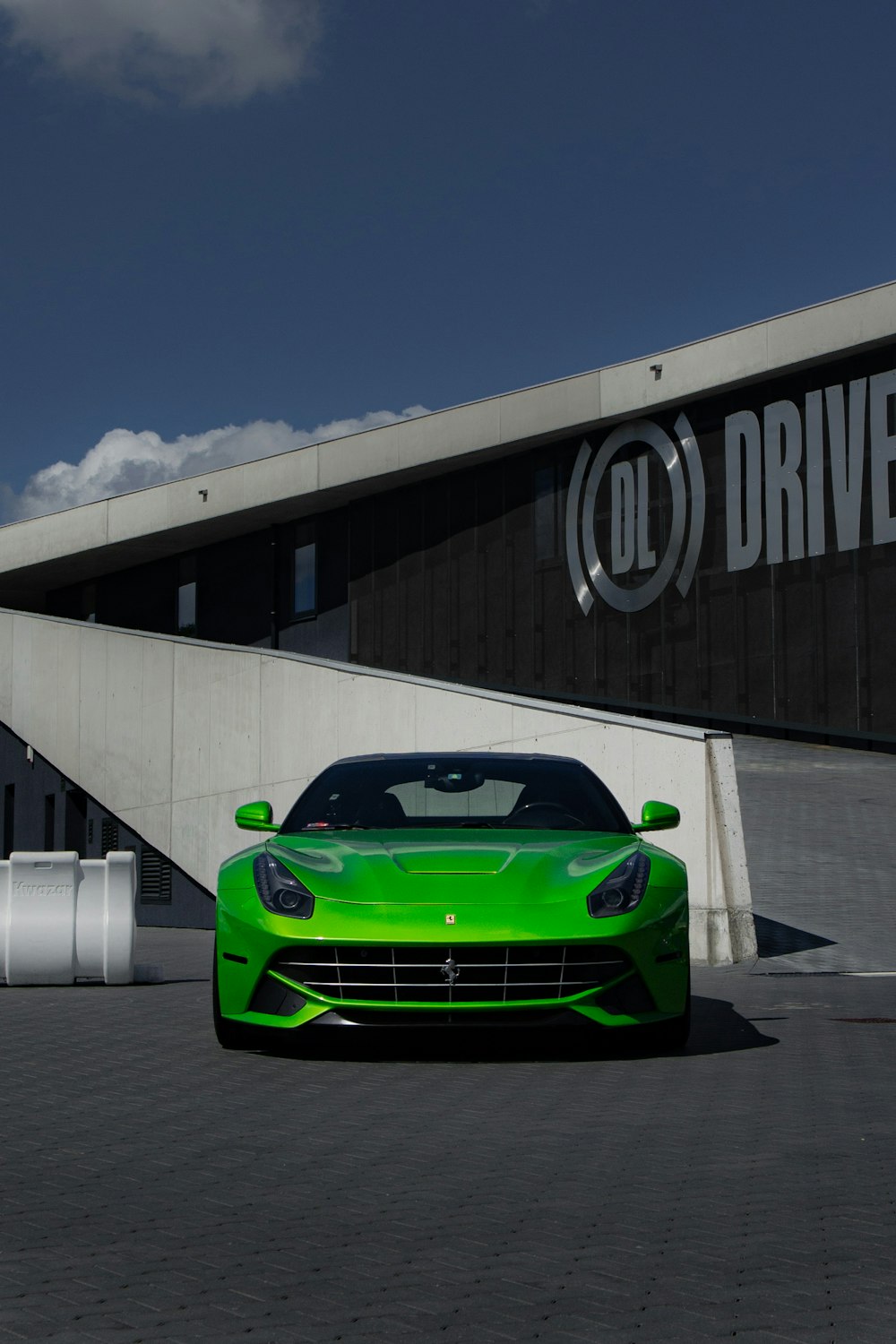 a green sports car parked in front of a building