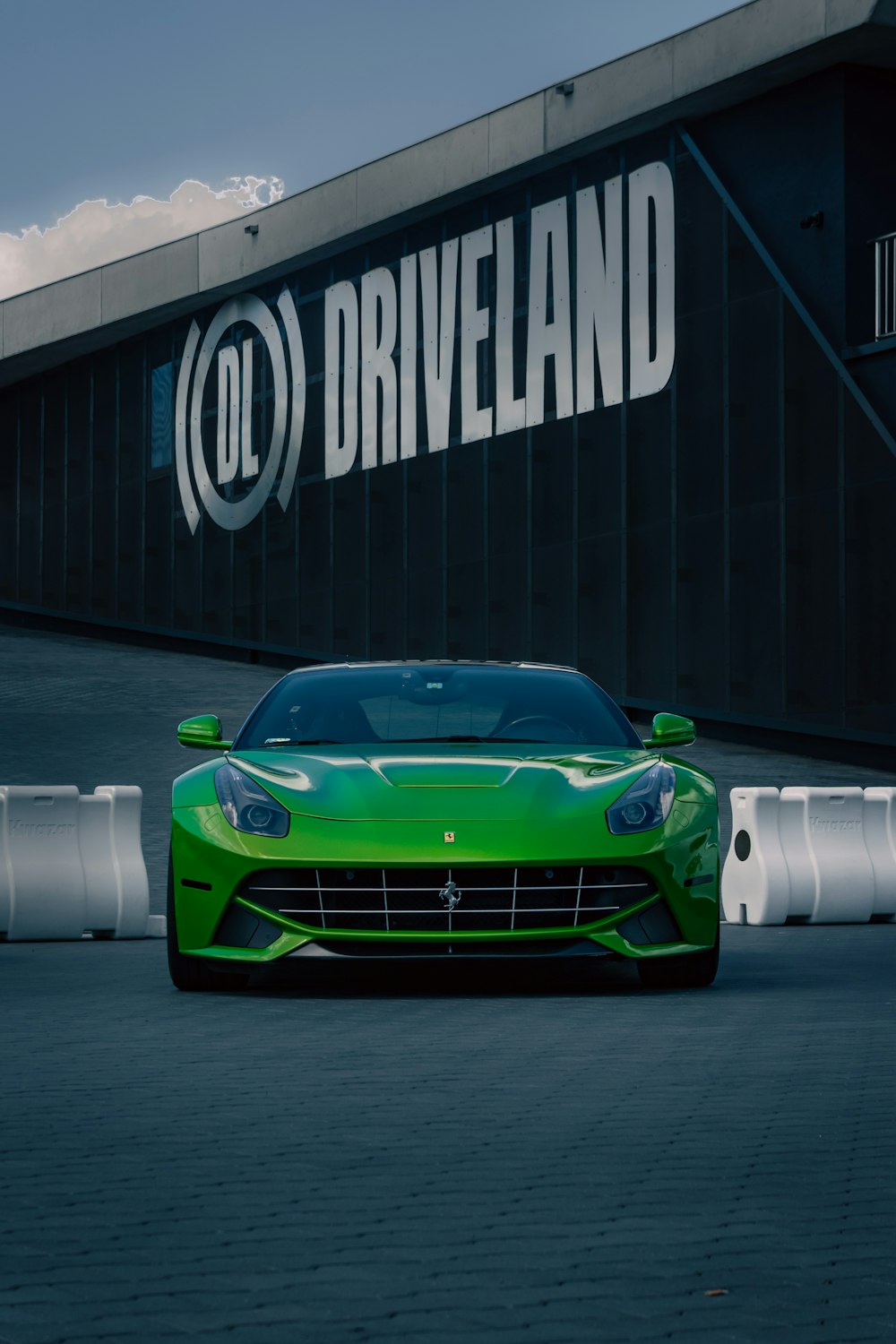 a green sports car parked outside a building