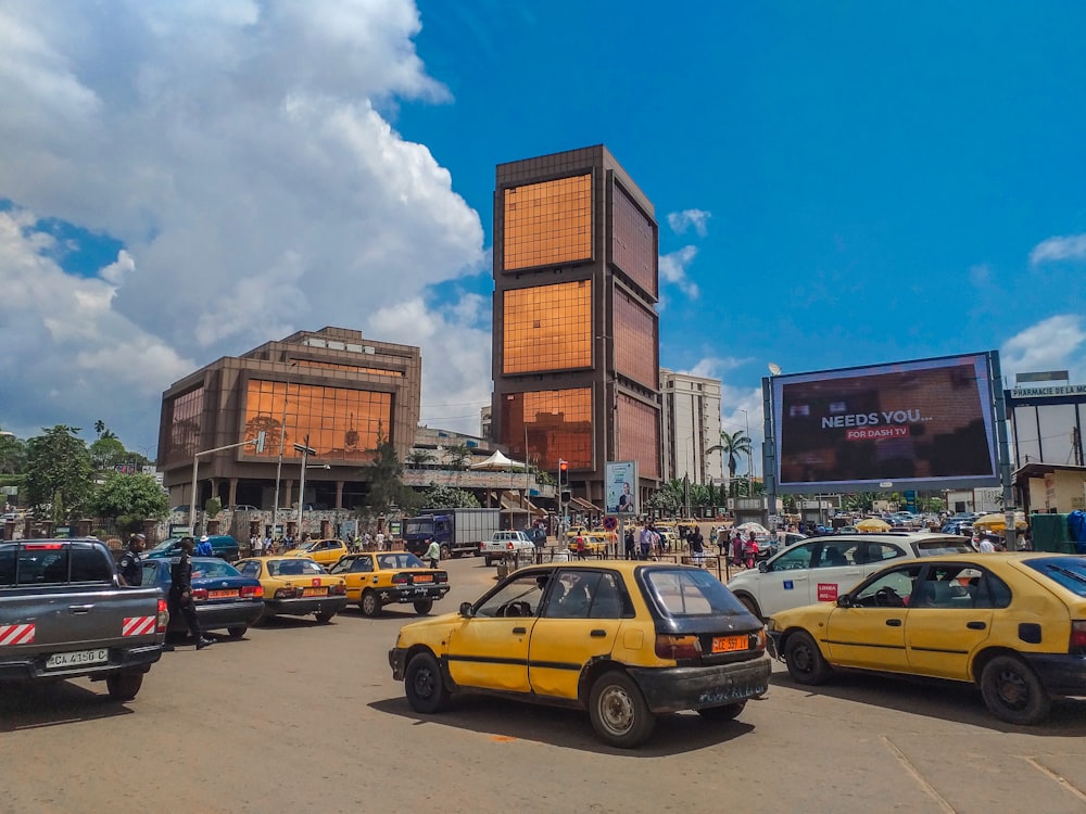 a group of cars parked in a parking lot with buildings in the background