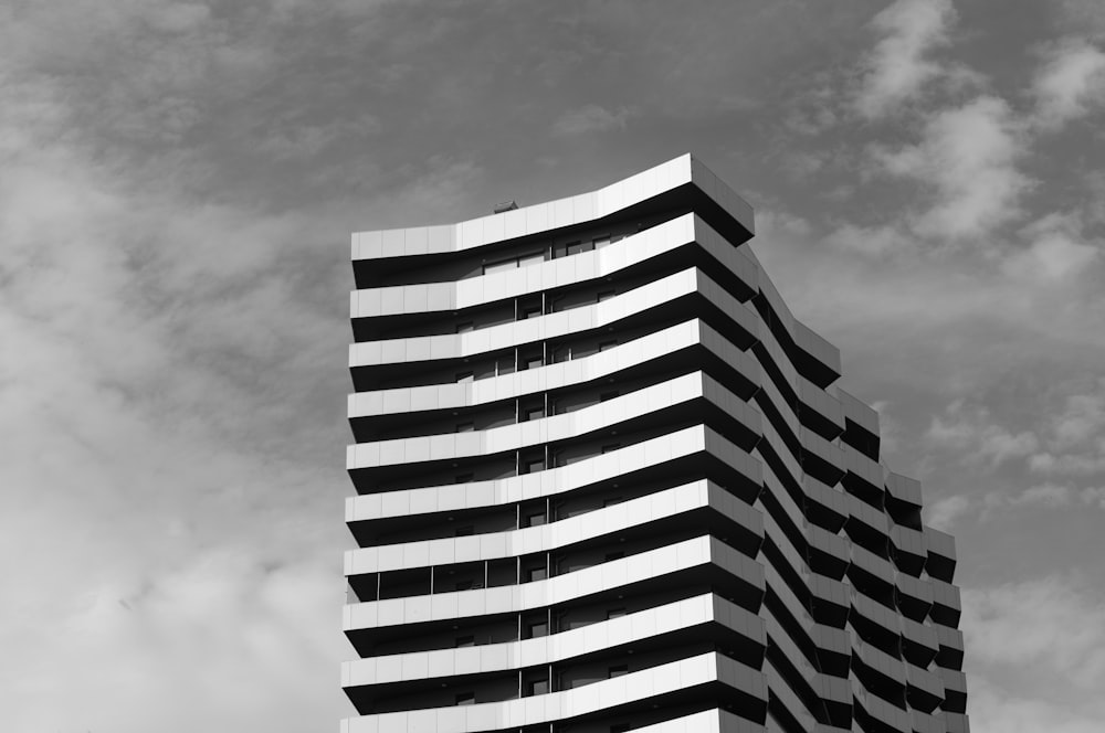 a tall building with clouds in the background