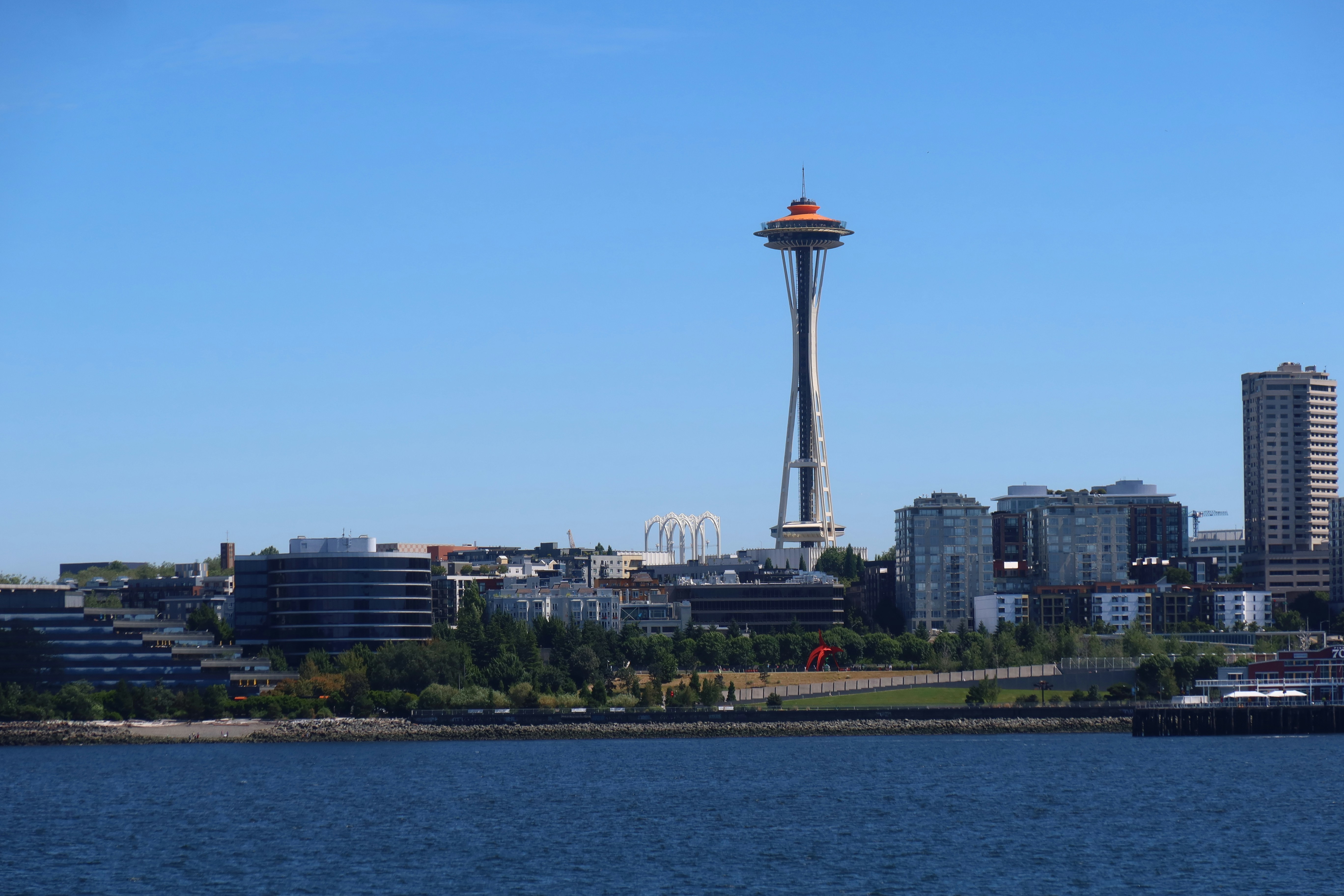 A view from the water of the Space Needle against a clear blue sky.