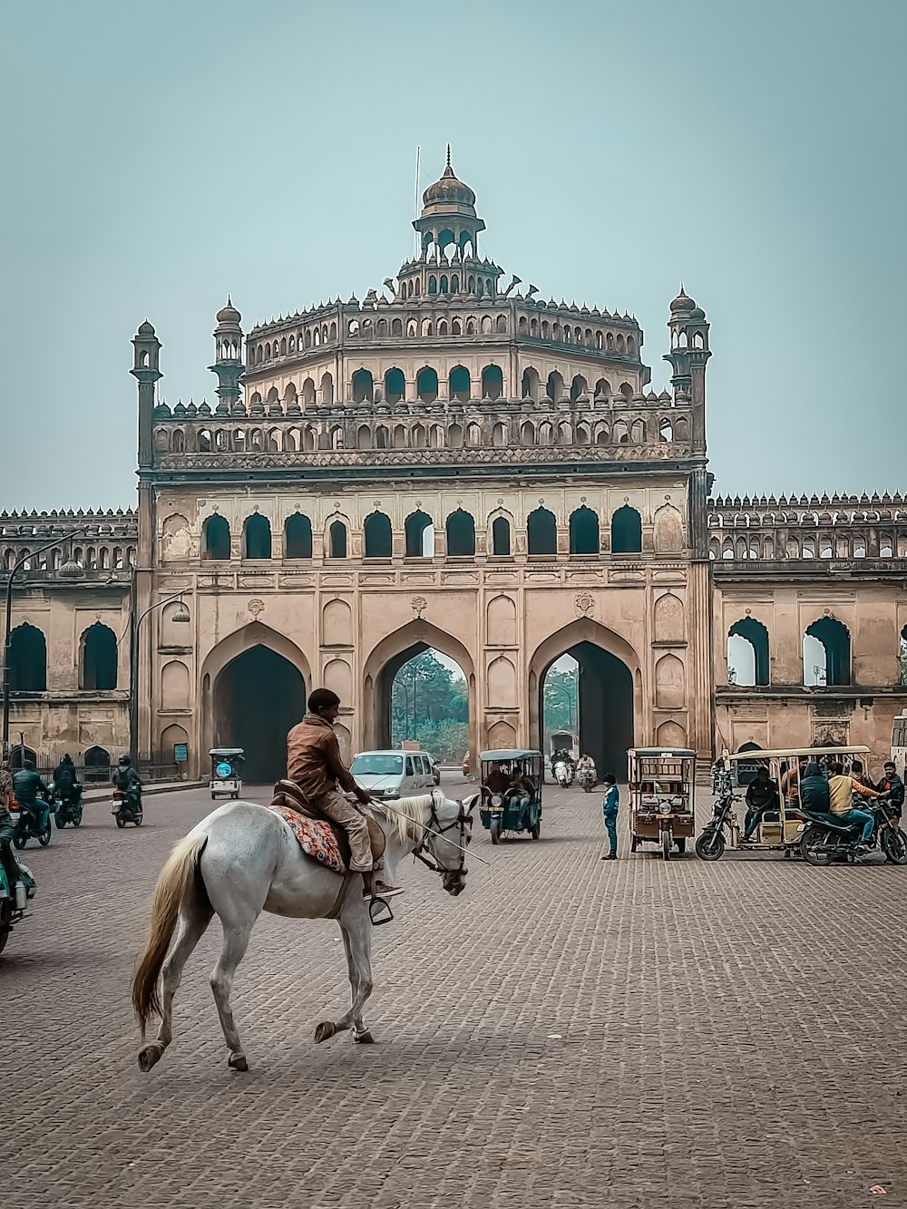 a person riding a horse in front of a large building