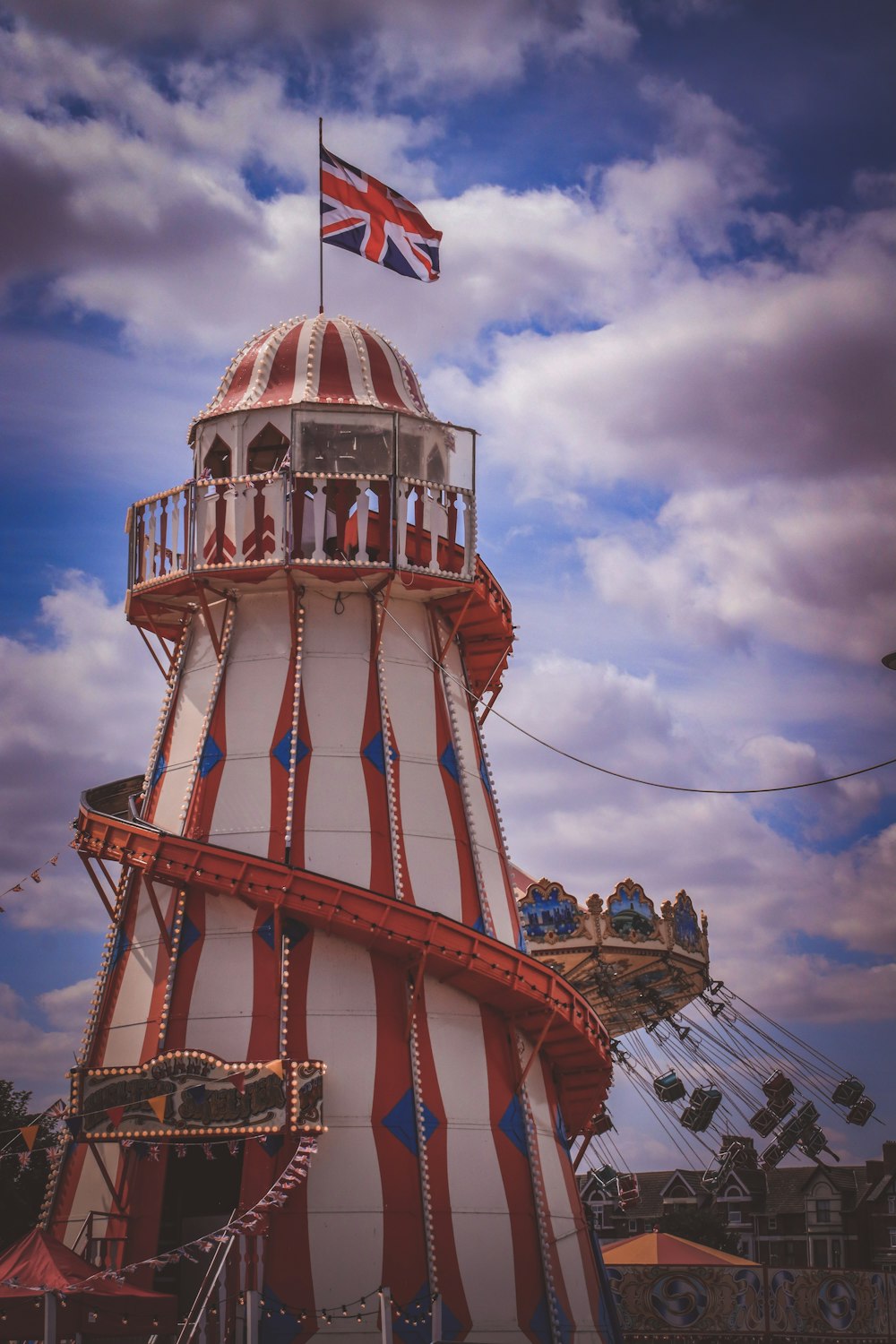a red and white tower with a flag on top