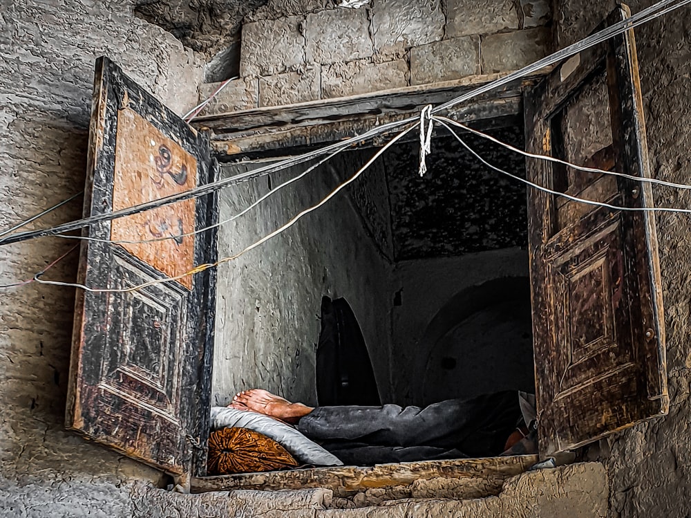 a person sleeping in a small stone tunnel