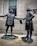 Two bronze statues depict historical figures in colonial attire. They stand facing each other, extending a handshake, with a building and a Masonic Temple plaque in the background. Snowflakes are visible, suggesting a cold atmosphere.