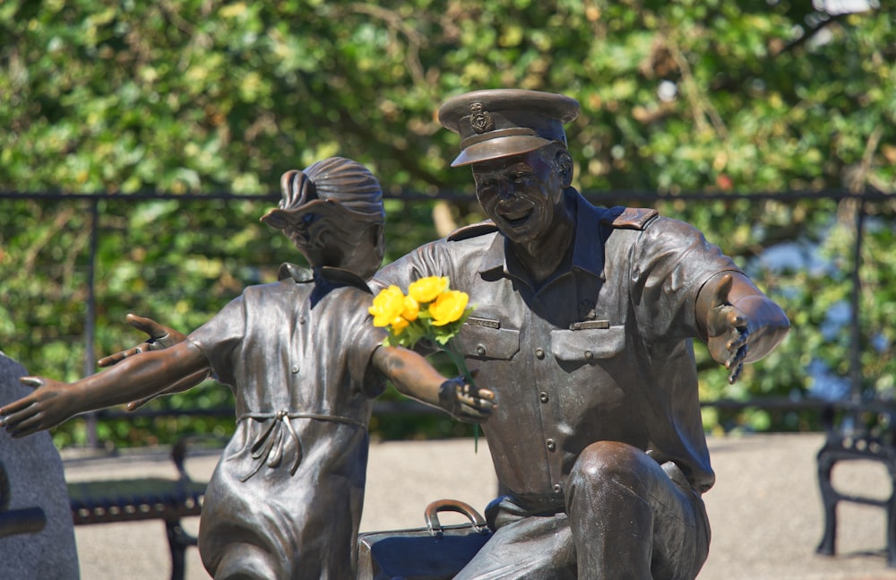 a statue of a man and a woman holding flowers