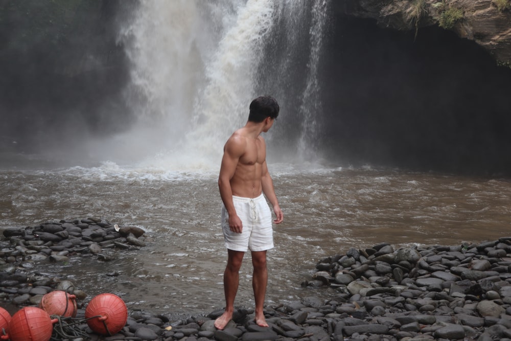 a man standing in front of a waterfall