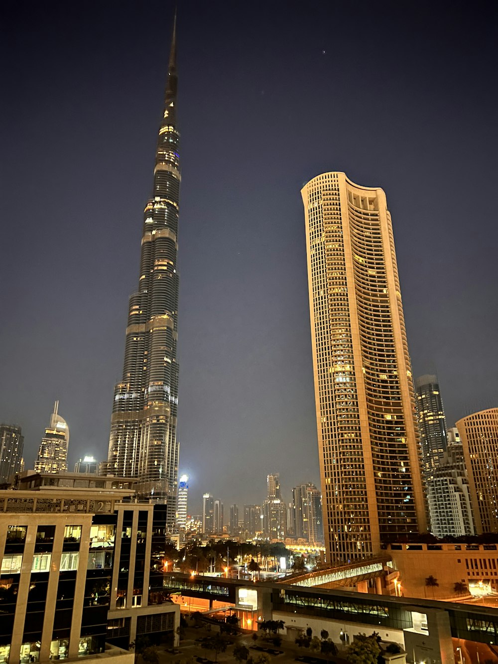 a couple of tall buildings in a city at night